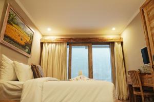 a bedroom with a bed and a large window at Koura Jimbaran in Badung