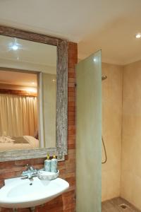 a bathroom with a sink and a mirror at Koura Jimbaran in Badung