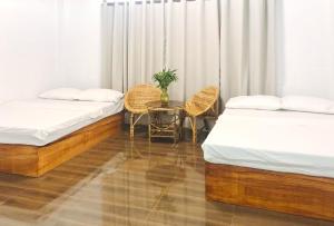 a room with two beds and a table and chairs at RedDoorz @ Ola Vida Casa Rental Ilocos Sur in Santa Catalina +11 photos