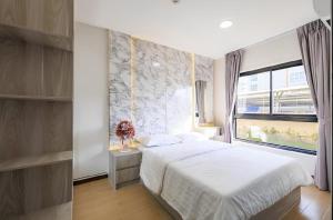 a bedroom with a white bed and a window at Raspberry Mansion ราสเบอรี่ แมนชั่น in Samutprakarn