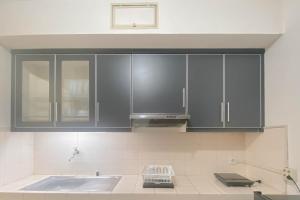 a kitchen with black cabinets and a sink at Spacious Luxury 2BR at Majesty Apartment By Travelio in Bandung +18 photos