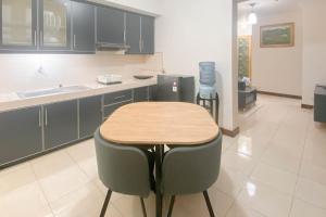 a kitchen with a table and two stools at Spacious Luxury 2BR at Majesty Apartment By Travelio in Bandung