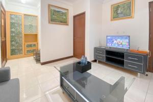 a living room with a tv and a glass table at Spacious Luxury 2BR at Majesty Apartment By Travelio in Bandung