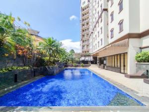 a swimming pool in front of a building at Spacious Luxury 2BR at Majesty Apartment By Travelio in Bandung