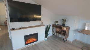 a living room with a fireplace with a flat screen tv at Mi Casa Mar in Mosonmagyaróvár