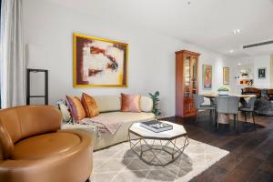 un soggiorno con un divano e un tavolo di Luxury 2B2B Albert Park Lakeside Apartment with Pool, Gym, Sauna & CarPark a Melbourne