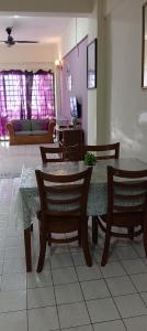 a dining room table and chairs with purple walls at Ground floor apartment Seaview beach in Port Dickson