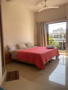 una camera da letto con un letto con una coperta rossa e una finestra di Casita Cocoa a Santa Cruz Huatulco
