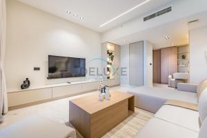 a living room with a couch and a tv at Sea and Palm Jumeirah Views Just Steps from the Beach 2BR, Sadaf 6 , JBR by Deluxe Holiday Homes in Dubai
