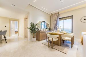 a dining room with a table and chairs and a mirror at Sea and Palm Jumeirah Views Just Steps from the Beach 2BR, Sadaf 6 , JBR by Deluxe Holiday Homes in Dubai