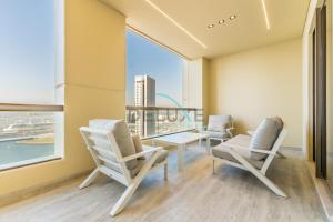 a room with two chairs and a table and a window at Sea and Palm Jumeirah Views Just Steps from the Beach 2BR, Sadaf 6 , JBR by Deluxe Holiday Homes in Dubai