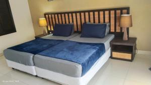 a large bed with blue pillows in a bedroom at CStone Legacy Gold Coast Morib Resort in Banting +20 photos
