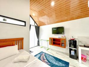 a bedroom with a bed and a flat screen tv at Diyanis Glamping Sekipan Tawangmangu Mitra RedDoorz in Tawangmangu