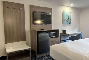 a hotel room with a bed and a flat screen tv at Baymont by Wyndham Indianapolis Northeast in Indianapolis