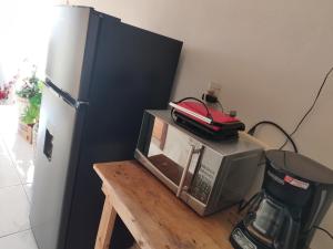 a microwave sitting on a table next to a refrigerator at Casita Cocoa in Santa Cruz Huatulco