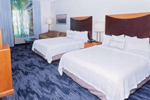 a hotel room with two beds and a living room at AmericInn by Wyndham Hays in Hays +18 photos