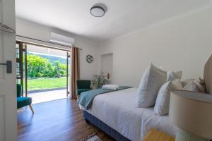 a bedroom with a bed and a sliding glass door at Seaside Family Villa in Wilderness