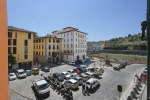 un parcheggio con auto, moto e edifici di Le Grazie Suite 2 in Florence a Firenze