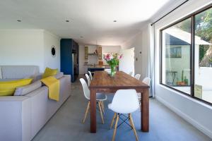 a dining room and living room with a table and a couch at Seaside Family Villa in Wilderness