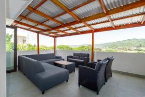 a living room with couches and chairs and a large window at Seaside Family Villa in Wilderness