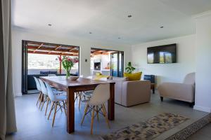 a dining room and living room with a table and chairs at Seaside Family Villa in Wilderness