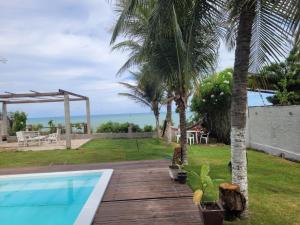 a swimming pool with a view of the ocean at Suites Dupla beira mar Carapibus in Conde