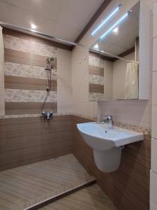 a bathroom with a sink and a mirror at Апартамент Сандански Център in Sandanski