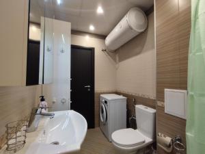 a bathroom with a white toilet and a sink at Апартамент Сандански Център in Sandanski +8 photos
