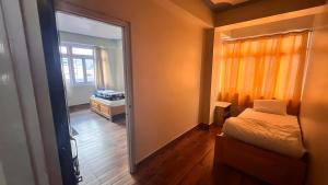 Un dormitorio pequeño con una cama y un espejo. en Hotel Rigyal, en Lachung 20 fotos más