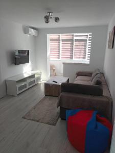 a living room with a couch and a television at apartament de inchiriat in loc Moinesti in Moineşti