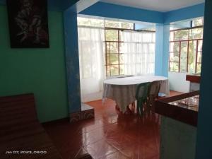 a dining room with a table in a room with windows at Hidden Hill Inn in Sagada