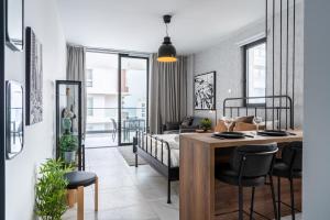 een slaapkamer met een bed, een tafel en stoelen bij Dusk - Harmonic Studio by Plus 49 in Mackenzie in Larnaka