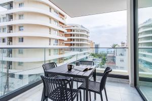 een eetkamer met een tafel en stoelen op een balkon bij Dusk - Harmonic Studio by Plus 49 in Mackenzie in Larnaka