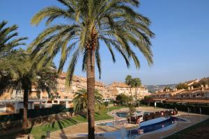a palm tree in front of a resort at Bungalow 7 Jávea in Jávea