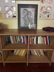 una libreria piena di libri con una foto sopra di Moyo Mmoja Guesthouse a Bagamoyo