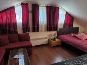 a living room with red curtains and a couch at Апартамент-студио Б4-4-1 Божурленд in Bansko +42 photos