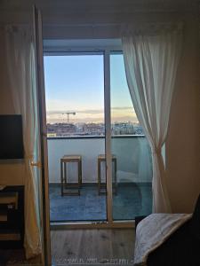 a bedroom with a large window with a view of the city at Cozy Urban Heaven with Dedicated Parking Spot in Sofia