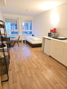 a room with a bed and a kitchen with a table at Apartments EFDE Boardinghouse Heilbronn in Heilbronn