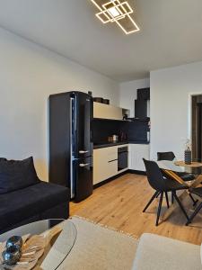 a living room with a black refrigerator and a kitchen at Cozy Urban Heaven with Dedicated Parking Spot in Sofia