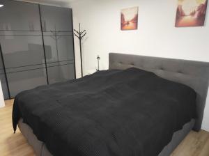 a bedroom with a bed with a black blanket at Ferienwohnung Sauer in Tiefenbach