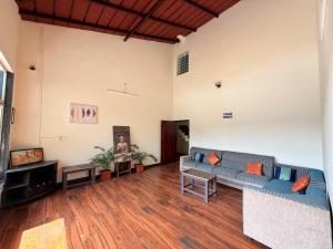 a living room with a couch and a tv at Gadabanahalli Homestay in Vastāra