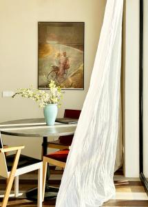a dining room with a table and a painting at Laimingi namai in Palanga