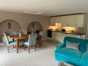 a living room with a table and a blue couch at Boutique village property in Broughton