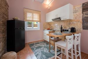 a kitchen with white cabinets and a black refrigerator at Nikas Guest House in Kanálion