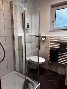 グレーミッツにあるStrandkrabbe - Haus 25のトイレとガラスのシャワー付きのバスルーム +4枚の写真