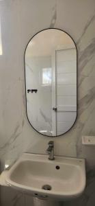 a bathroom with a white sink and a mirror at The Waterfront Beach Resort in Morong