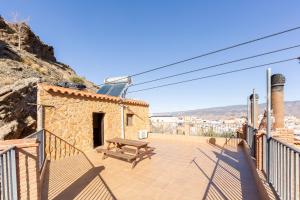 a patio with a wooden bench and a building at Casa Rural La Jirola -Vivienda 2 in Escúllar