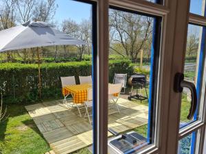 a view of a table and an umbrella from a window at Le logis du heron in Coulon