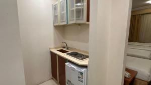 Una pequeña cocina con fregadero y estufa. en فندق رشيد الفضي, en Al Hindāwīyah