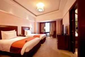 a hotel room with two beds and a television at Xian heng Hotel in Shaoxing